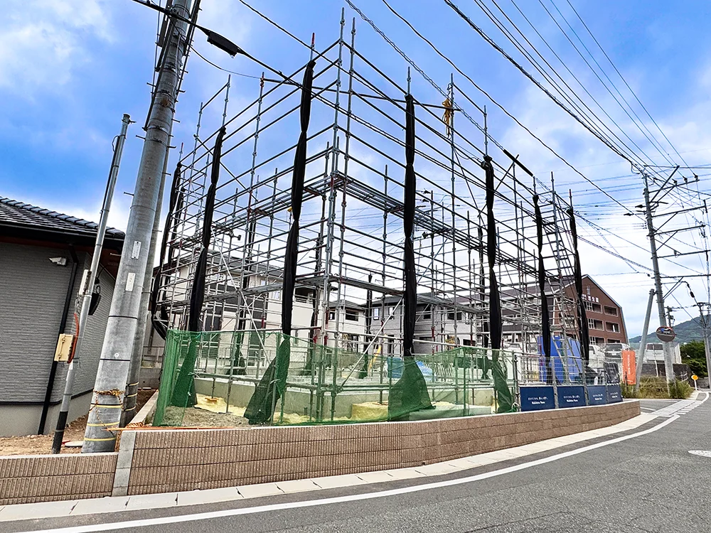 足場が設置され上棟準備が進む建築現場