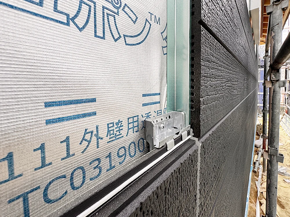透湿防水シートの上に金具で留め付けられた外壁材