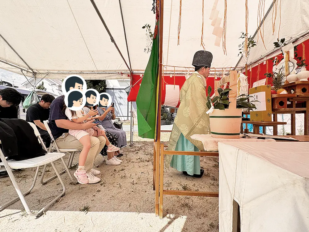 祭壇の前で神事を執り行う神主と、それを見守るご家族