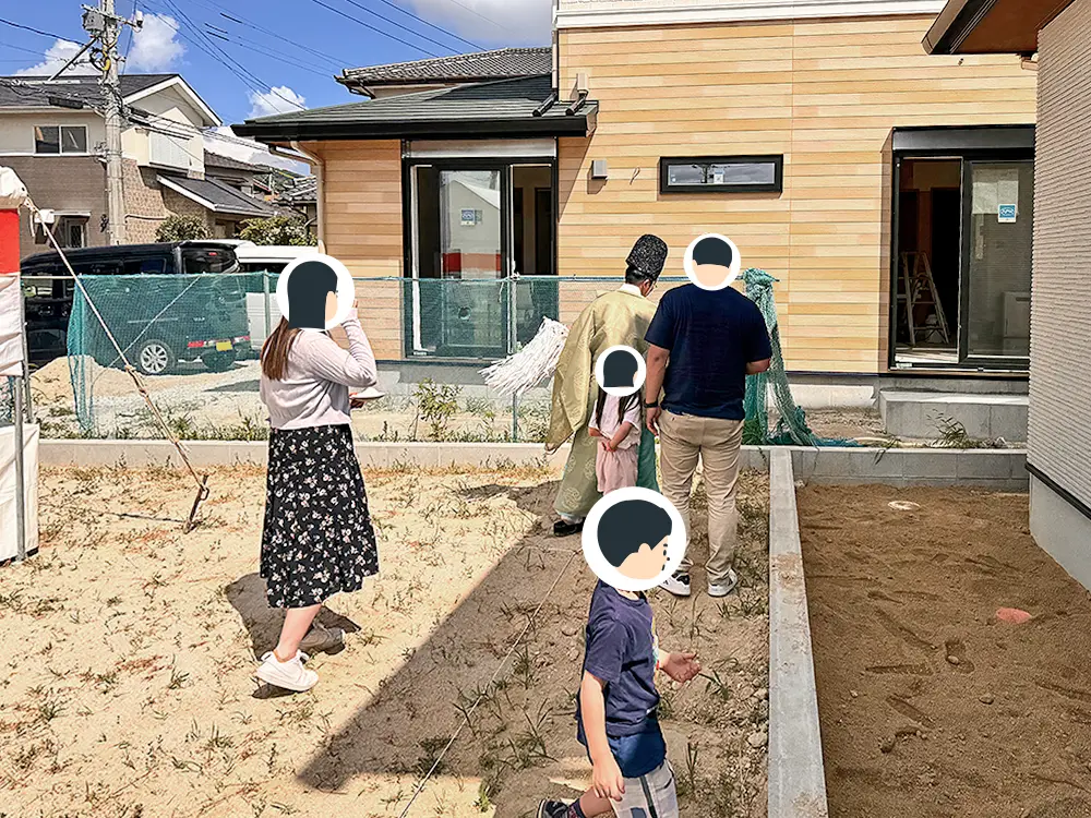 神主とご家族が敷地を歩いて四方祓いに向かう様子