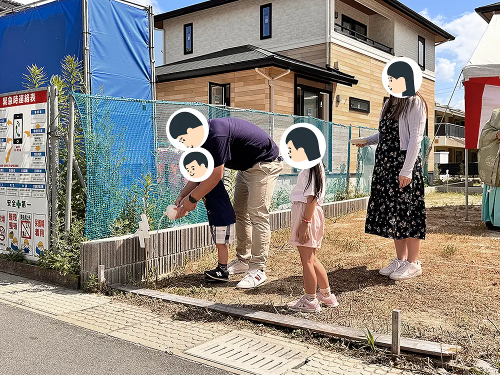 工事用フェンス側の隅をご家族そろってお清めする様子