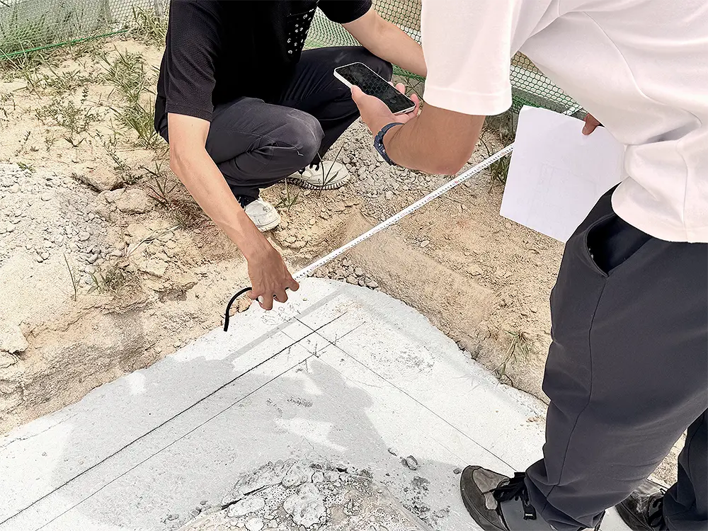 地墨の位置をメジャーで測り、図面と照合するスタッフ