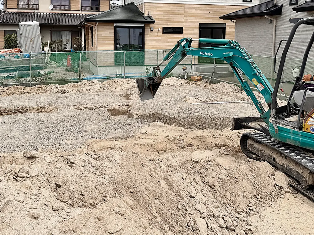 砕石を敷き込み、基礎の下地を整えていく現場