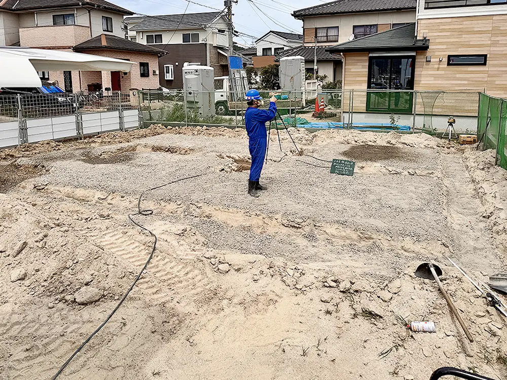 基礎内の地盤面へ防蟻処理の薬剤を散布する職人
