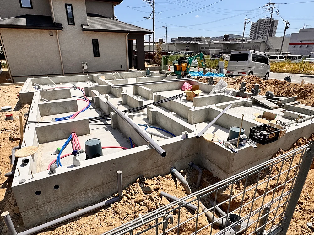 基礎の周囲に給排水の配管が施工された現場の全景