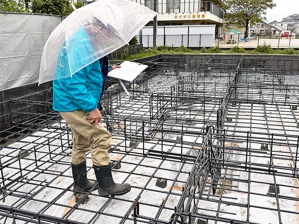 図面と照合しながら配筋を確認する検査員